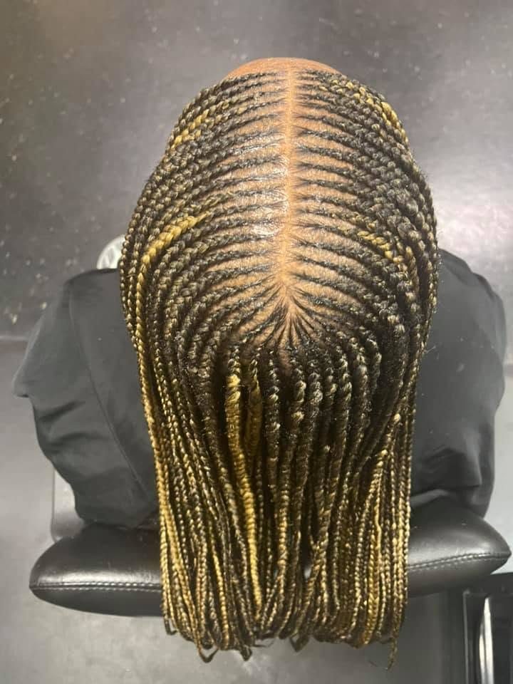 Back view of long box braids with gold hair extensions in radiant pattern