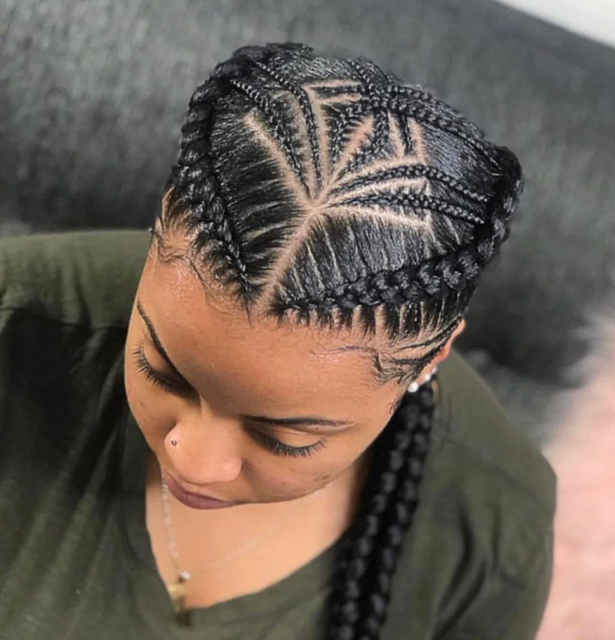 Woman with braided updo hairstyle featuring geometric patterns and cornrows