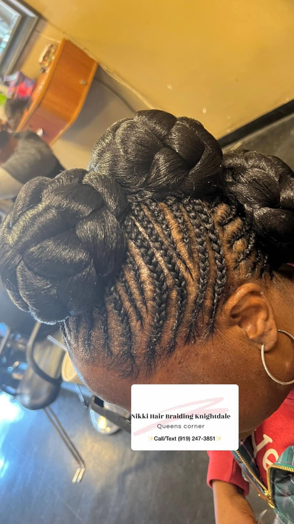 Back view of braided hairstyle with buns and gold accents at salon