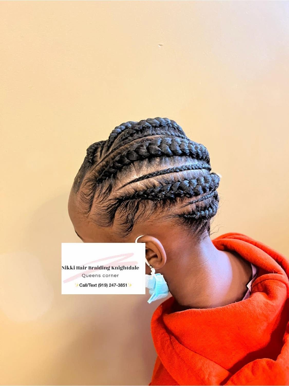 Back view of intricate braided hairstyle with multiple twisted braids on person wearing red jacket
