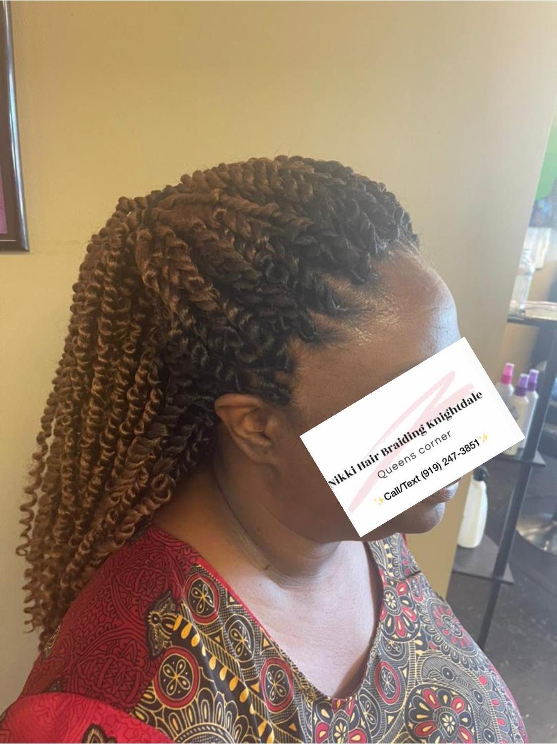 Side profile of woman with braided hairstyle featuring cornrows and twisted braids in brown tones