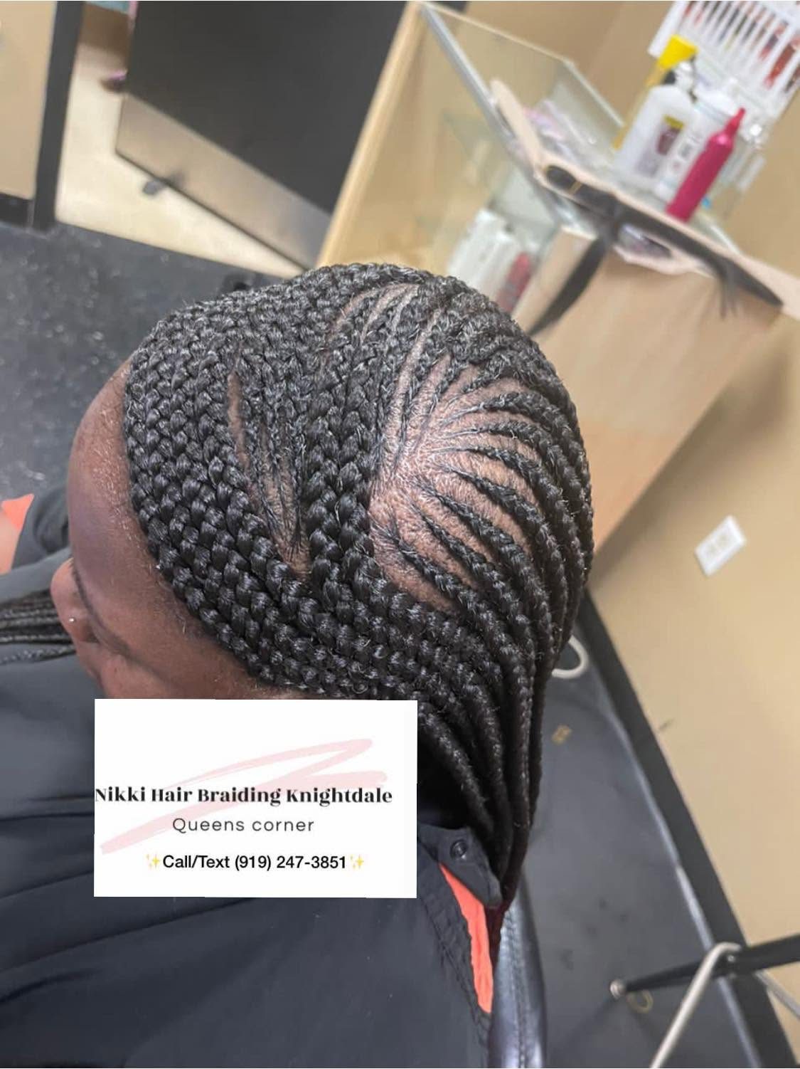 Back view of cornrow braids styled on a client's head in a salon setting