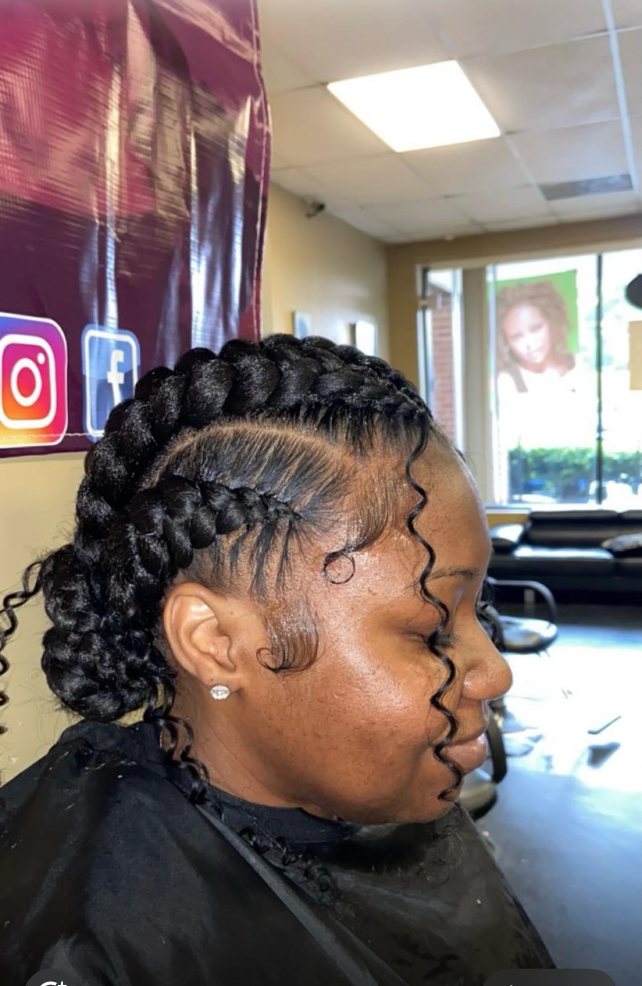 Woman with braided updo hairstyle and wavy hair designs in salon interior