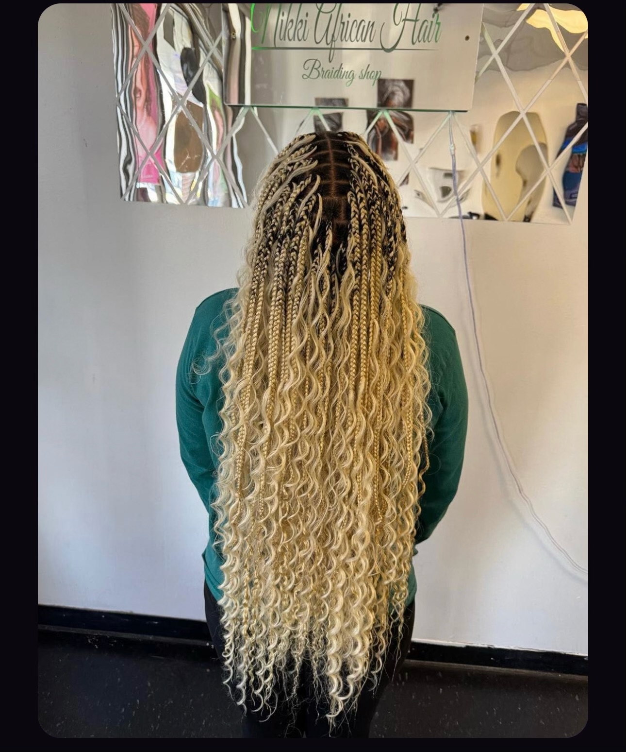 Back view of woman with long blonde box braids in braiding shop